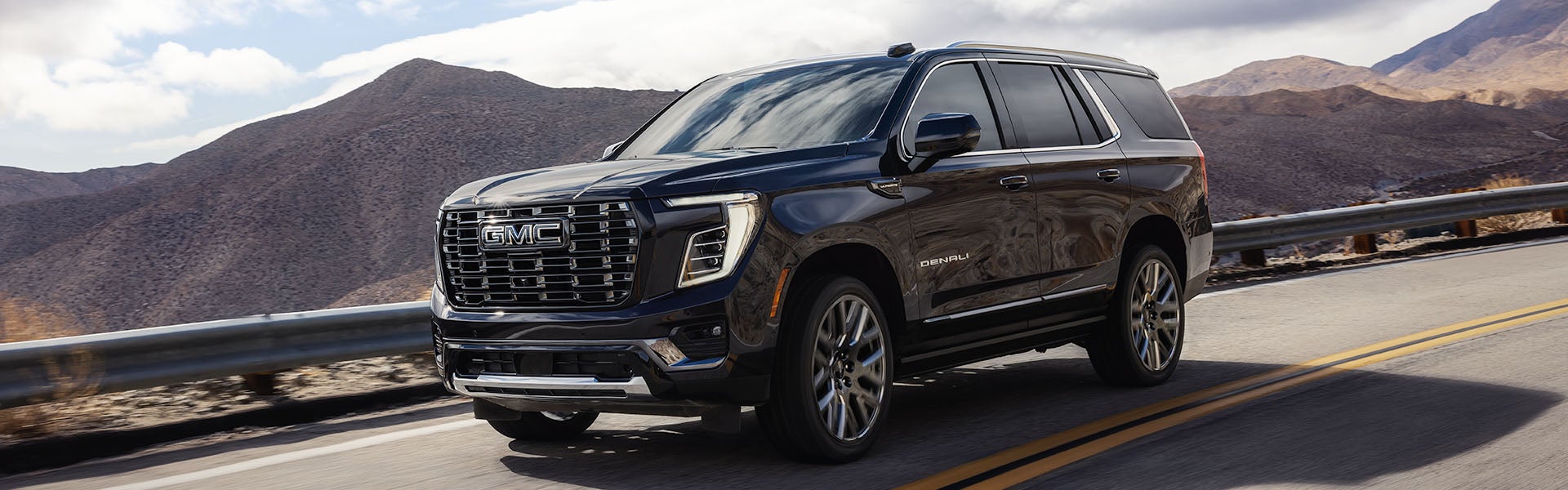 2026 GMC Yukon driving on a scenic mountain highway