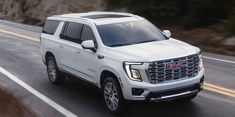 Front three-quarter view of the 2026 GMC Yukon driving on the road